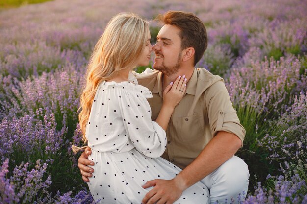 Pareja de Provenza relajante en campo de lavanda. Dama con un vestido blanco.