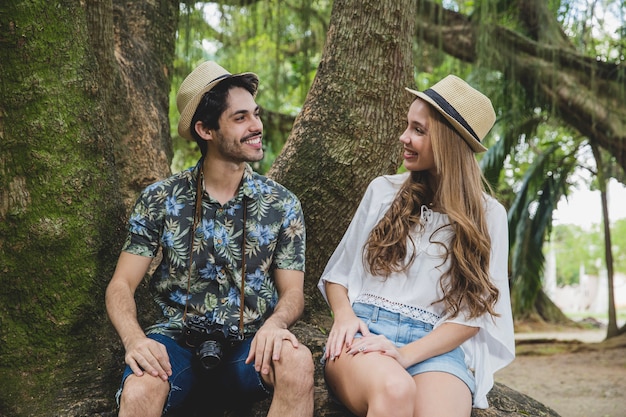 Pareja en raíz de árbol mirando uno al otro