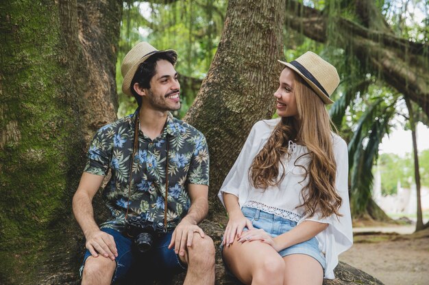 Pareja en raíz de árbol mirando uno al otro