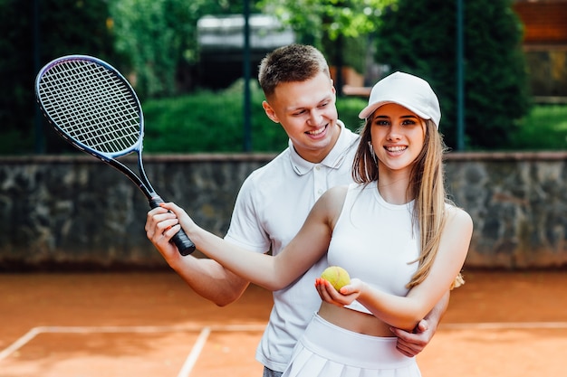 Pareja con raquetas de tenis en cancha al aire libre