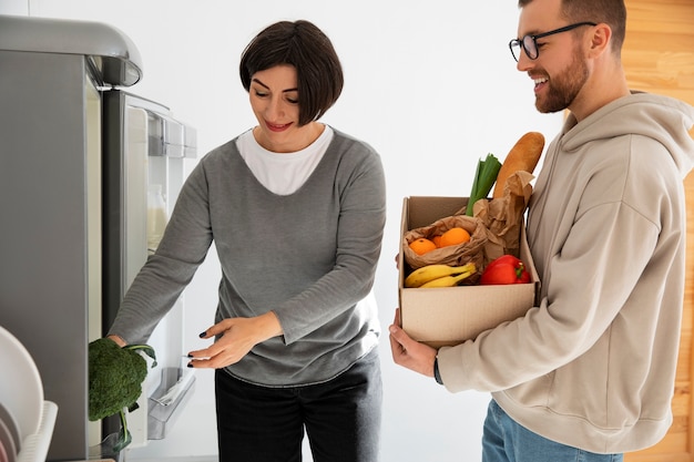 Foto gratuita pareja recibiendo una entrega de comestibles