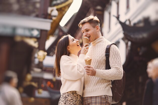 Pareja de recién casados comiendo helado de un cono en una calle de Shanghai, cerca de Yuyuan, China.