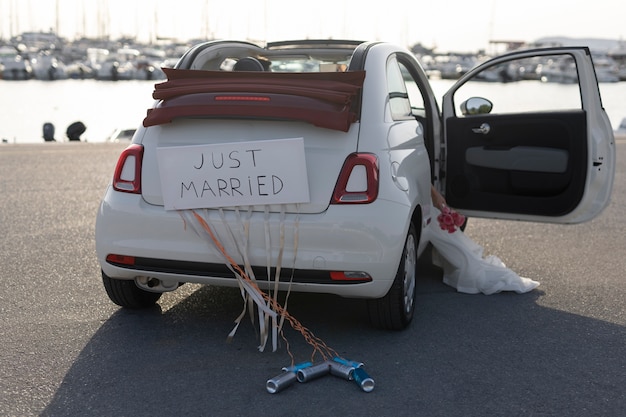 Una pareja de recién casados dentro de un auto pequeño