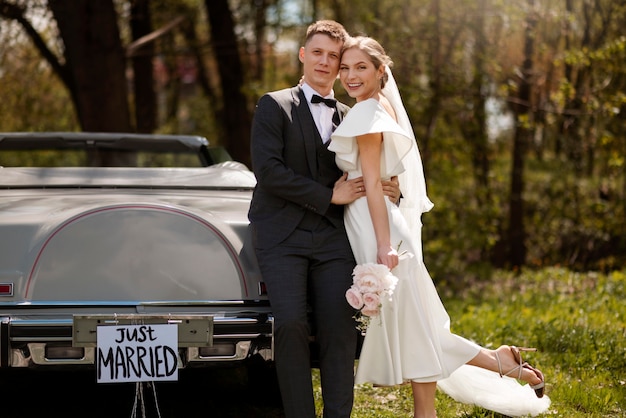 Pareja de recién casados con su coche