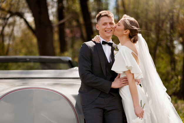 Pareja de recién casados con su coche