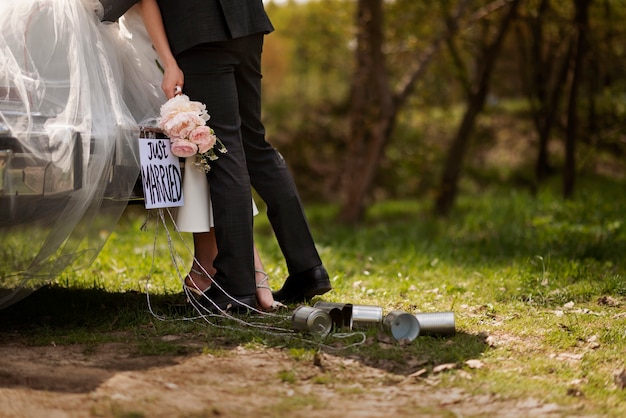 Pareja de recién casados con su coche