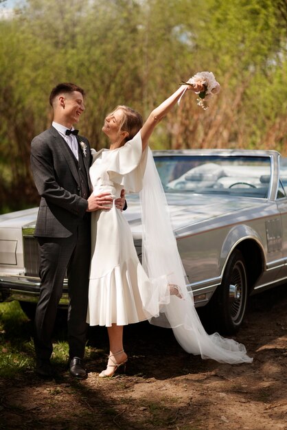 Pareja de recién casados con su coche