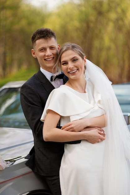 Pareja de recién casados con su coche