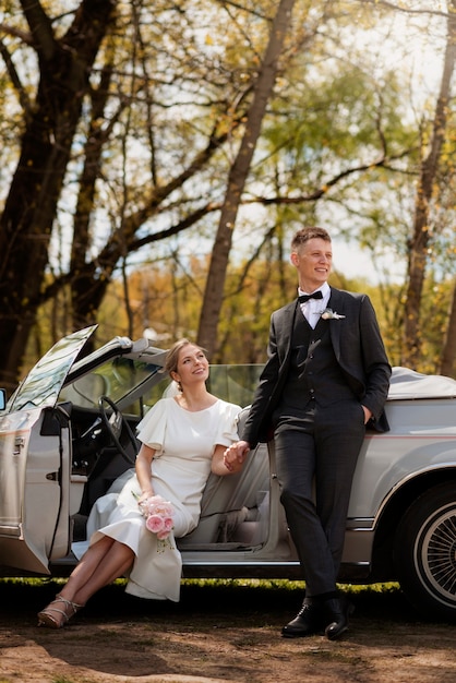 Pareja de recién casados con su coche