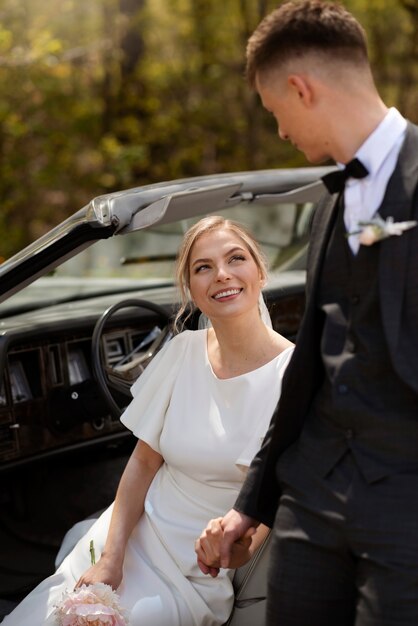 Pareja de recién casados con su coche