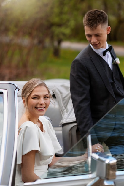 Pareja de recién casados con su coche