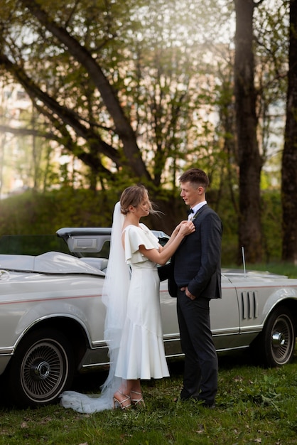 Foto gratuita pareja de recién casados con su coche