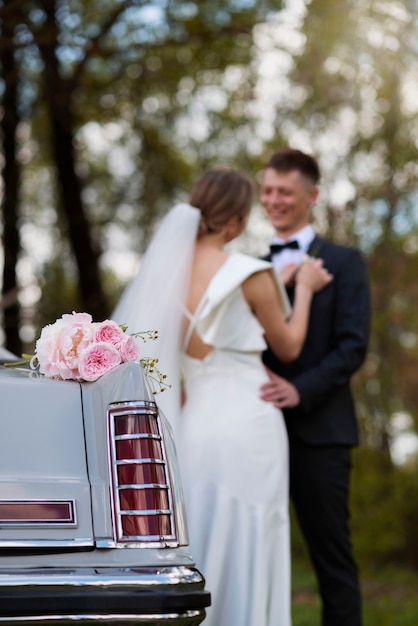 Pareja de recién casados con su coche