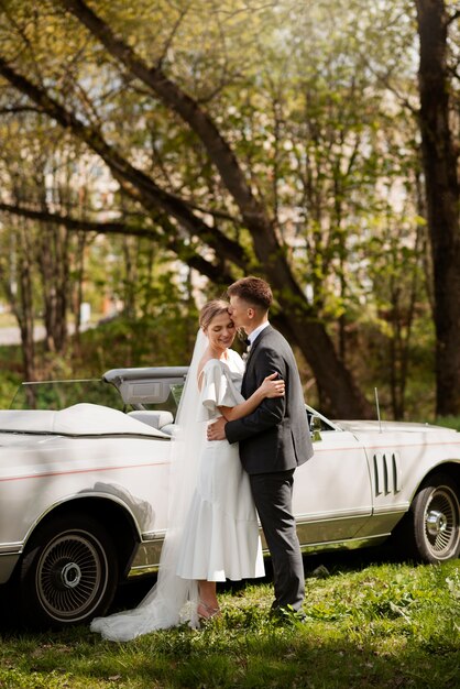 Pareja de recién casados con su coche