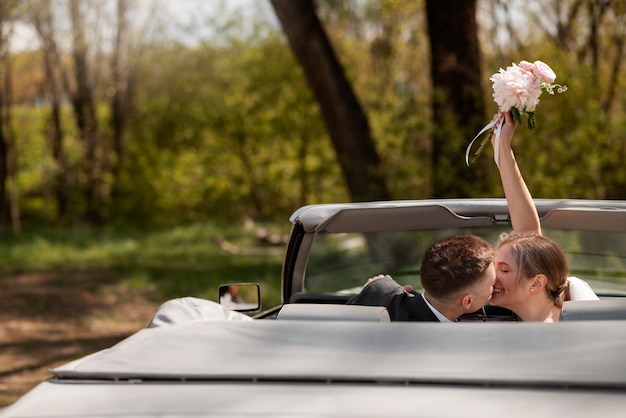 Foto gratuita pareja de recién casados con su coche