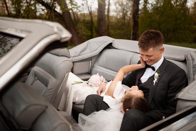 Foto gratuita pareja de recién casados con su coche