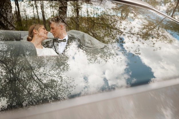 Pareja de recién casados con su coche