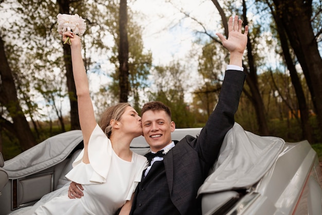 Foto gratuita pareja de recién casados con su coche