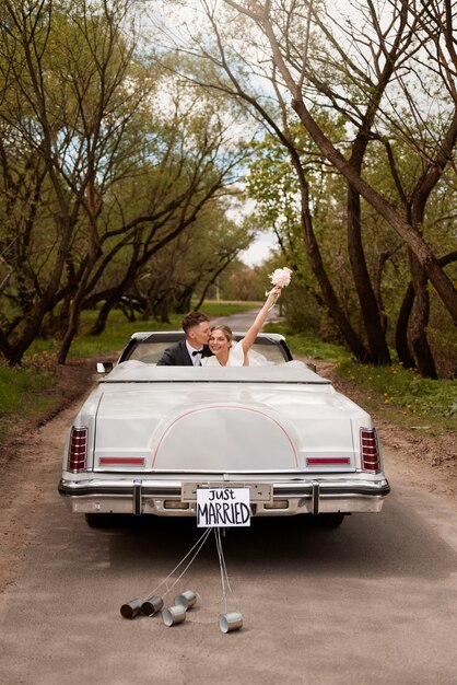 Pareja de recién casados con su coche