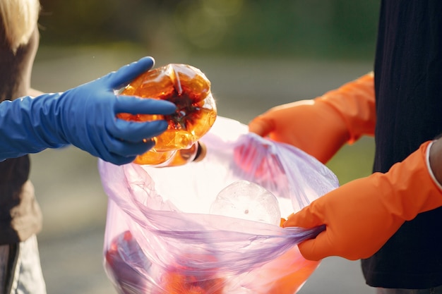 Pareja recoge basura en bolsas de basura en el parque