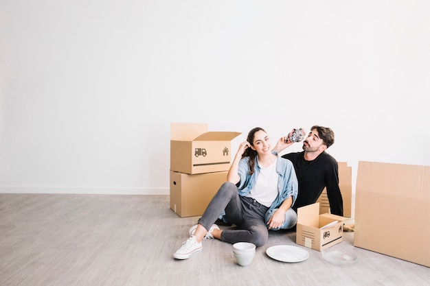 Pareja relajando con cajas de mudanza