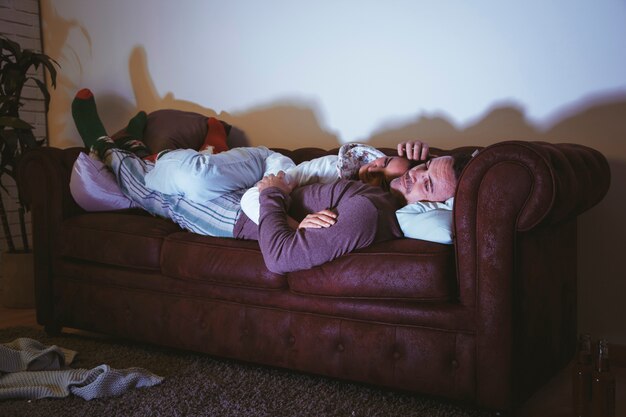 Pareja relajando en sofá y viendo una película