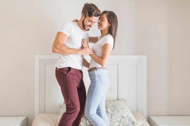 Pareja riendo y bailando en la cama