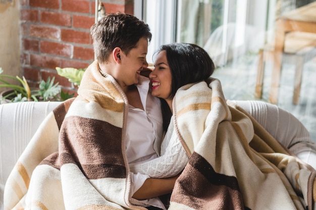 Foto gratuita pareja riendo tapados con una manta