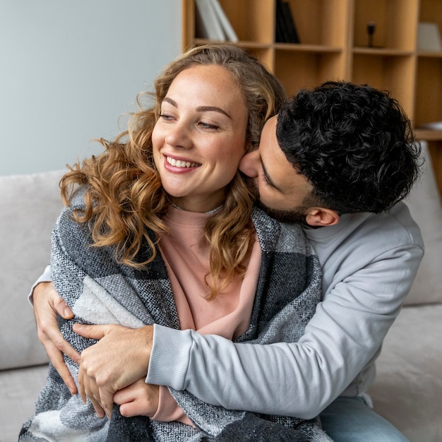 Foto gratuita pareja romántica abrazados en el sofá en casa