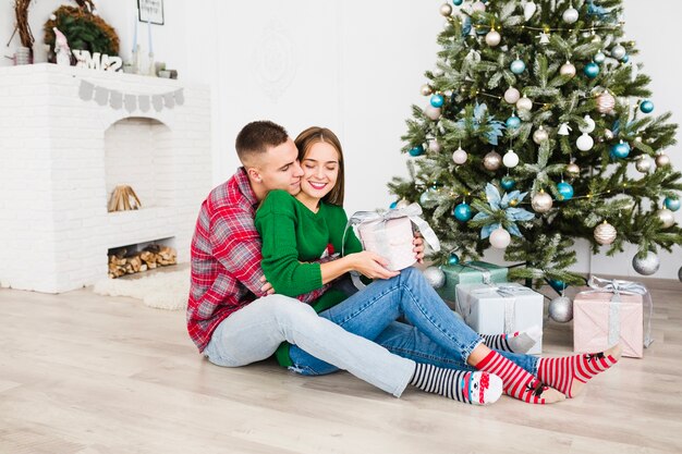 Pareja romántica al lado de árbol de navidad