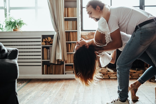 Una pareja romantica bailando en casa