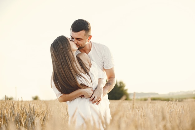 Pareja romántica en el campo de trigo en un día soleado