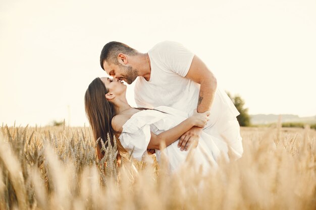 Pareja romántica en el campo de trigo en un día soleado