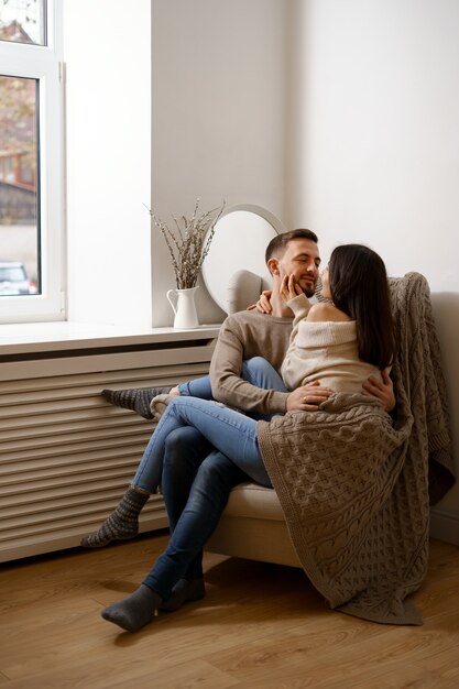 Pareja romántica en casa. Una mujer joven atractiva y un hombre guapo disfrutan de pasar tiempo