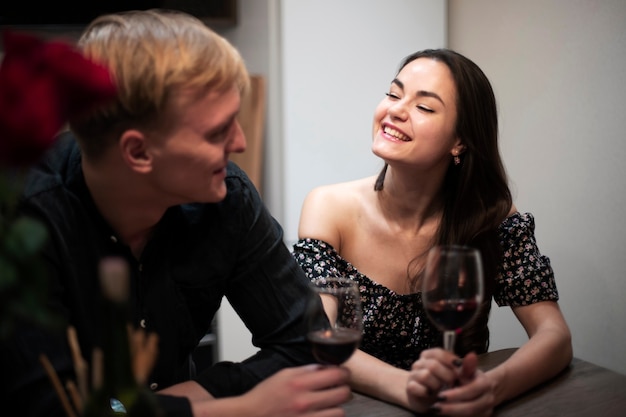 Pareja romántica celebrando el día de San Valentín en casa con vino