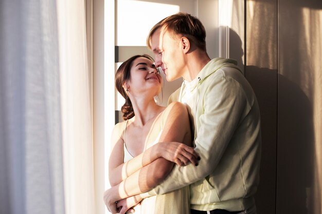 Pareja romántica celebrando el día de San Valentín juntos en casa abrazados