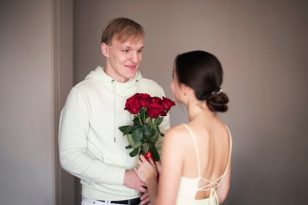 Pareja romántica celebrando el día de San Valentín con un ramo de rosas rojas