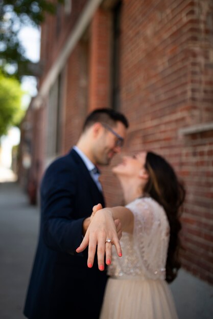 Pareja romántica en la ciudad mostrando anillo de compromiso