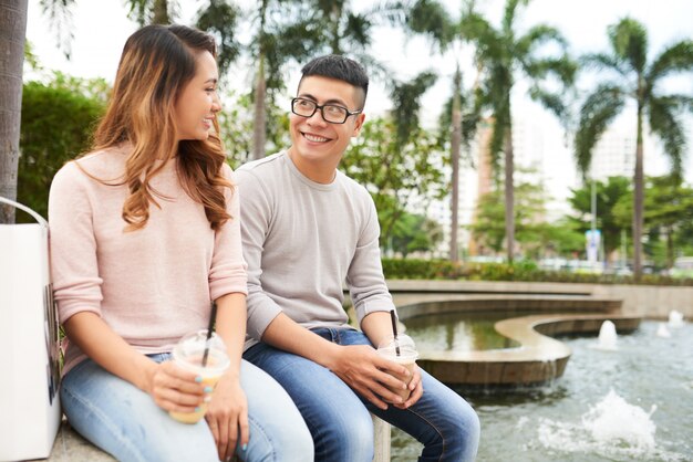 Pareja romántica descansando en gargen público en un cálido día de verano