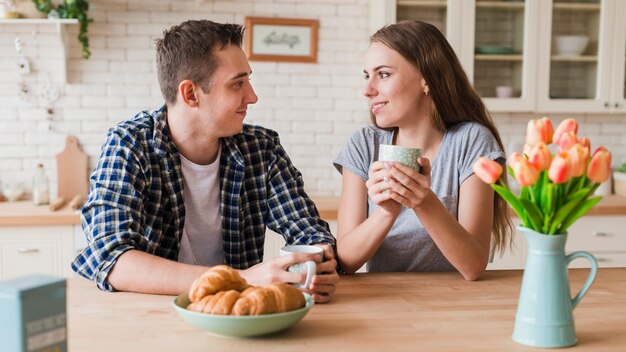 Pareja romántica descansando en la mesa y tomando té