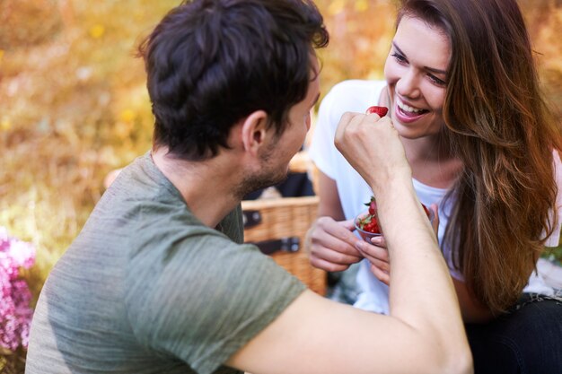 Pareja romántica disfrutando de un picnic en el parque