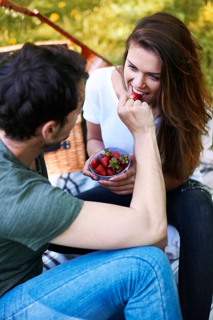 Pareja romántica disfrutando de un picnic en el parque