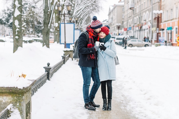 Pareja romántica con estilo en la calle cubierto de nieve
