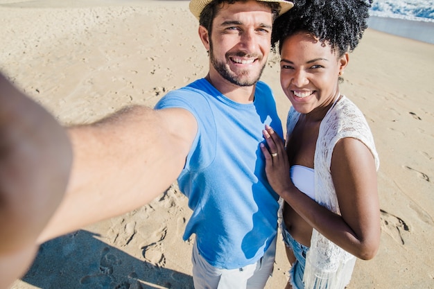 Foto gratuita pareja romántica haciendo un selfie en la playa