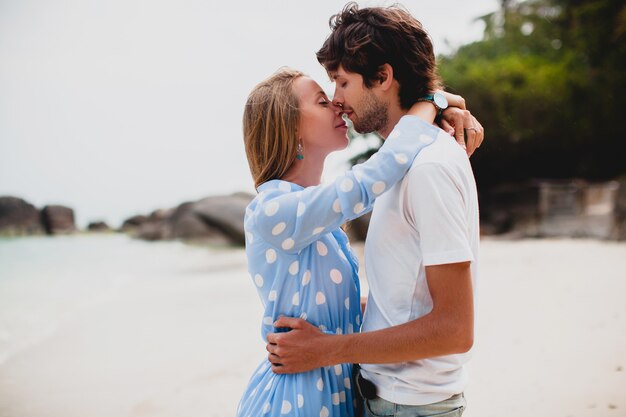 Pareja romántica joven inconformista con estilo en el amor en la playa tropical durante las vacaciones