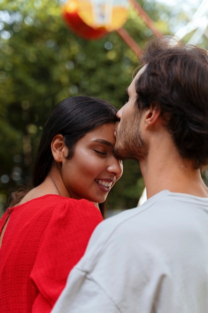 Foto gratuita pareja romántica juntos en la rueda de la fortuna en el parque