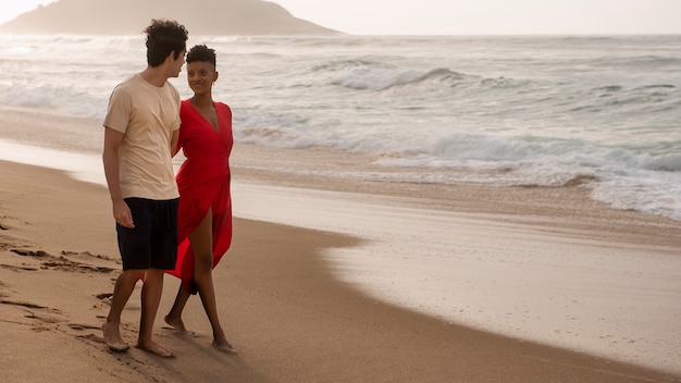 Pareja romántica mostrando afecto en la playa cerca del océano