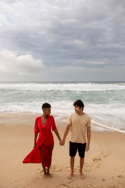 Pareja romántica mostrando afecto en la playa cerca del océano