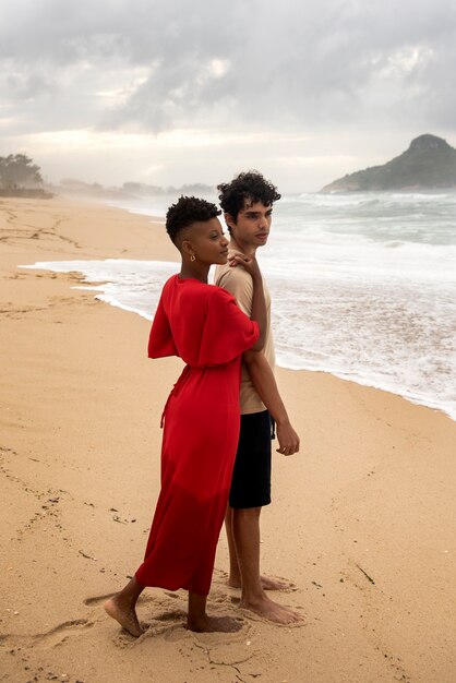 Pareja romántica mostrando afecto en la playa cerca del océano