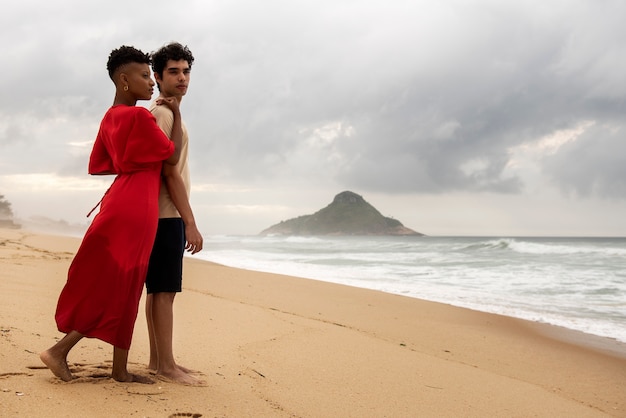 Pareja romántica mostrando afecto en la playa cerca del océano